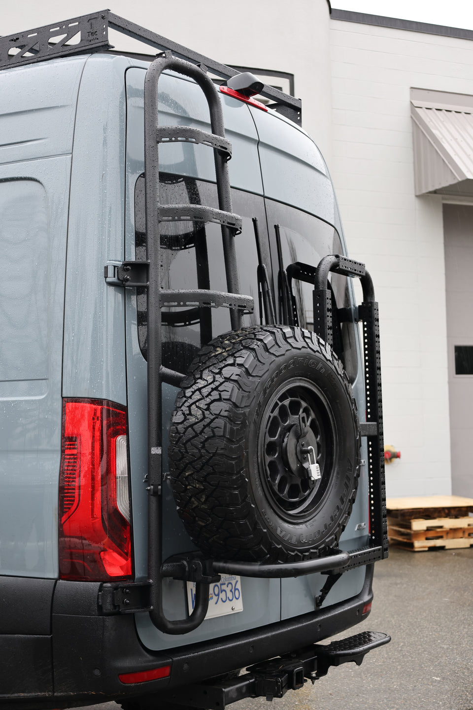 Sprinter rear-door tire ladder carrier with a mounted spare tire